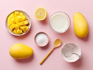 Ingredients for Fumang Propitious Mango Ice Cream flat laid on a pastel pink background