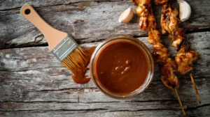 Low FODMAP BBQ sauce in jar with grilled chicken