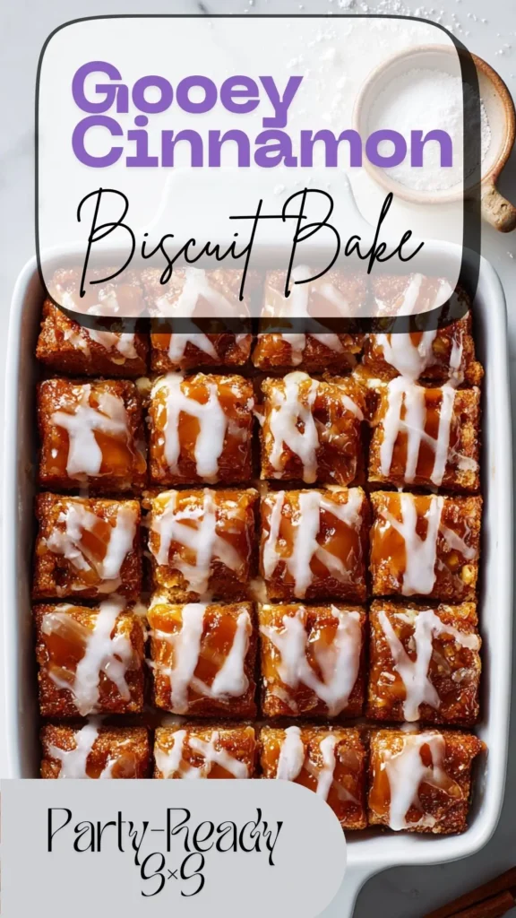 Overhead 9×9 gooey cinnamon roll biscuit casserole with cream-cheese pockets and vanilla glaze, one square removed on marble.