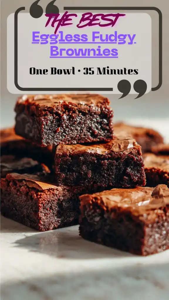 Side view square of eggless brownie with shiny crinkle top and fudgy center, clean slice on parchment, a few chocolate chips scattered.