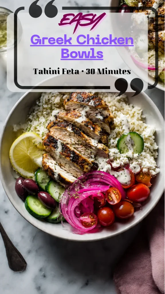 Bowl with sliced Greek chicken over herby rice, cucumbers, tomatoes, olives, pickled onion, and tahini-feta drizzle; lemon wedge; fresh herbs.