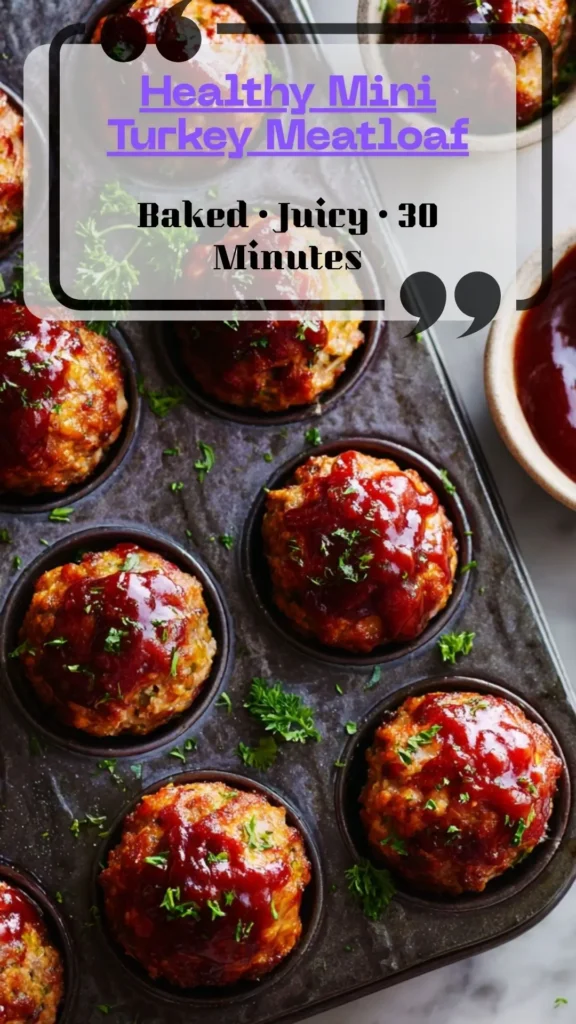Overhead muffin tin of glazed mini turkey meatloaves, shiny ketchup tops and parsley; portion-perfect, baked to 165°F, meal-prep ready.