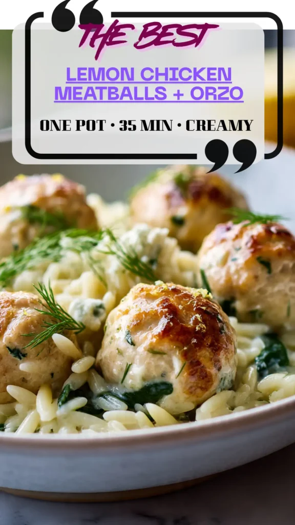 Bowl of creamy lemon orzo with spinach topped with baked lemon chicken meatballs; dill, feta, and lemon wedges on marble.