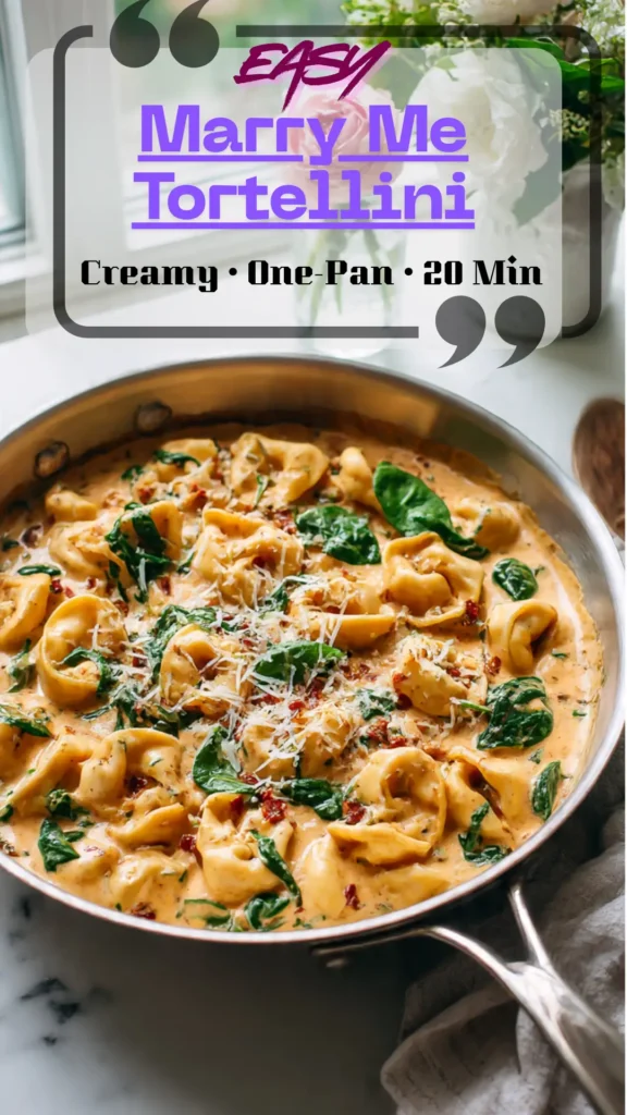 Skillet of creamy Marry Me Tortellini with sun-dried tomatoes, spinach, and Parmesan; glossy sauce coats pillowy pasta; fresh basil on top.