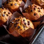 Freshly baked banana chocolate chip muffins on a cooling rack
