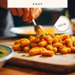 Plate of homemade sweet potato gnocchi topped with sauce and herbs
