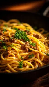 Creamy garlic butter pasta topped with ground beef on a plate