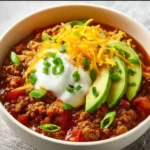 Bowl of Best Keto Crock Pot Chili topped with herbs and cheese