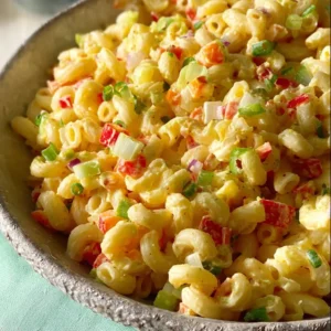 Delicious homemade macaroni salad served in a bowl with colorful vegetables