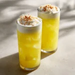 Coconut Pineapple Italian Soda in a glass with ice and tropical decoration.