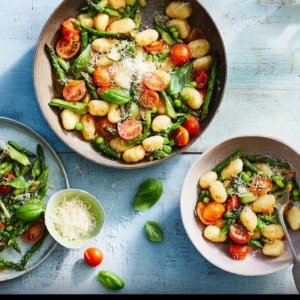 Fresh asparagus pasta with cherry tomatoes in a bowl.