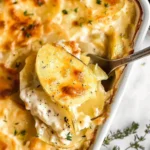 Baked scalloped potatoes without cheese served in a dish.