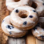Freshly baked sourdough discard blueberry donuts with icing