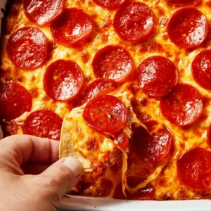 Creamy cottage cheese pizza dip served in a bowl with fresh herbs.