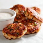 Cheesy chicken fritters served with dipping sauce on a platter
