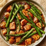 Garlic Butter Chicken Bites served with fresh asparagus on a plate