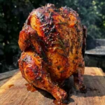 Grilled beer can chicken infused with fresh herbs on the barbecue grill