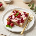 Raspberry Cottage Cheese Baked Oatmeal in a bowl, topped with fresh raspberries.