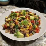 A colorful bowl of Southwest Quinoa Salad with fresh vegetables and dressing