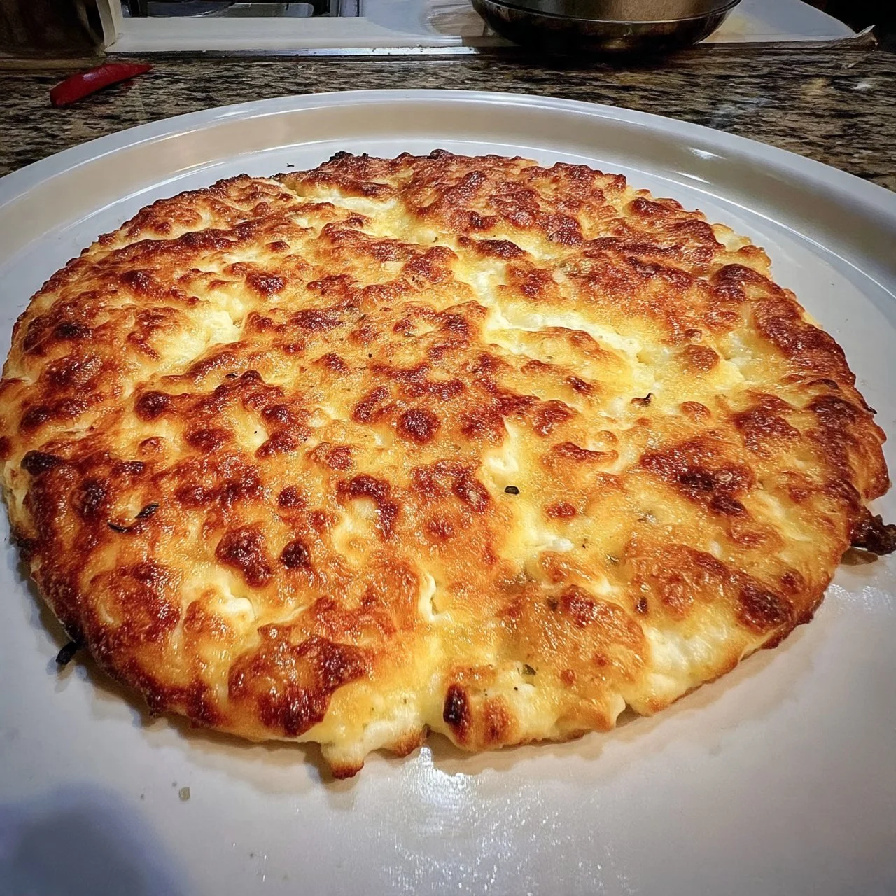 Viral cottage cheese flatbread topped with herbs and spices on a plate.