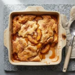 Delicious fresh Southern peach cobbler served warm with a scoop of ice cream