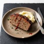 Delicious grilled meatloaf served on a plate with a side of vegetables.