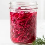 Bowl of quick pickled red cabbage garnished with herbs