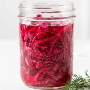 Bowl of quick pickled red cabbage garnished with herbs