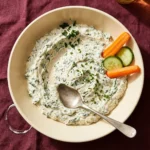 Ranch spinach dip with cottage cheese served in a bowl, garnished with herbs.