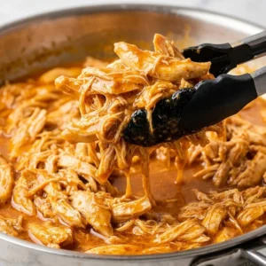 Slow cooker shredded chicken tacos garnished with fresh cilantro and lime.
