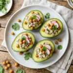 Healthy tuna salad stuffed avocado garnished with fresh herbs and served on a plate