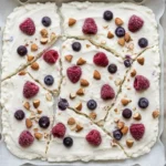 Frozen cottage cheese bark topped with fruits and nuts for a healthy dessert.