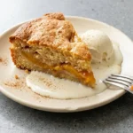 Deliciously easy peach cobbler served warm with a scoop of vanilla ice cream