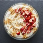 Delicious strawberry cheesecake bowl topped with fresh strawberries and cream