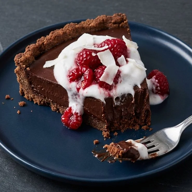 No-bake vegan chocolate tart topped with fresh berries and nuts
