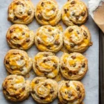 Golden brown sausage cheddar biscuits on a plate, perfect for breakfast.