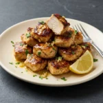 Delicious garlic butter chicken bites on a plate garnished with herbs